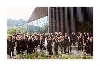 Bundes Jugend Orchester stehen zusammen. Sie tragen schwarze Klamotte