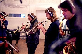 4 Musiker spielen Trompete und Saxophone