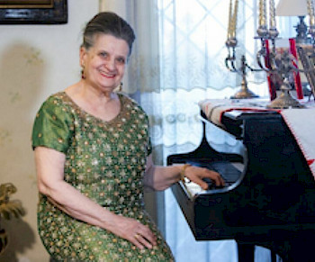 Marcella Crudeli sitzt vor ihrer Klavier und lächelt
