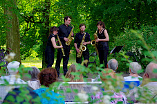 4 Musiker spielen auf Saxophonen auf einer open air-Bühne