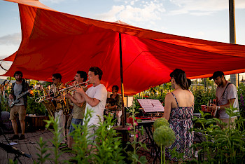 Das Ensemble Oluma spielt unter einem roten Segel (Photo: Flo Bayomi)