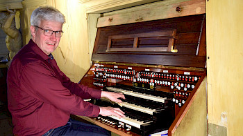 Ein Mann spielt eine alte Orgel