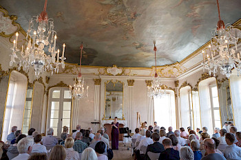 Konzertbesucher in einem barocken Saal