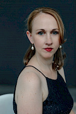 Porträt von einer jungen Frau mit weißen Tränenohringen, roten Lippen und schwarzer Kleid
