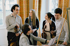 5 Musiker, 3 Männer und 2 Frauen, sprechen und lachen zusammen