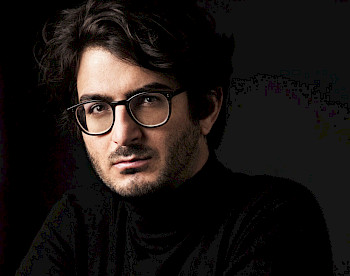 Poträt von Matan Porat: Er trägt schwarze Klamotte und Brille