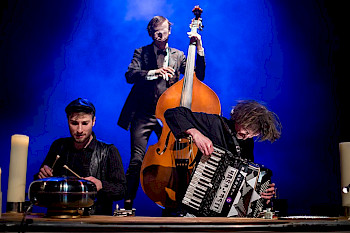 Drei Musiker spielen Musik: Ein spielt Akkordeon, ein Kontrabass, ein Schlagzeug