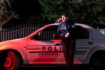 Ein Polizist steht vor seinem Wagen
