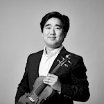 Ein asiatischer Violinist lächelt in die Kamera