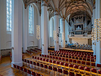 Gewölbesaal mit Orgel und leeren Sitzreihen