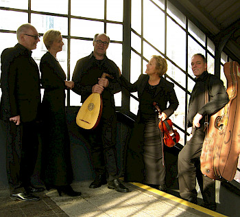 Eine Ensemble steht mit seinen Instrumenten auf einer Bahnhofstreppe