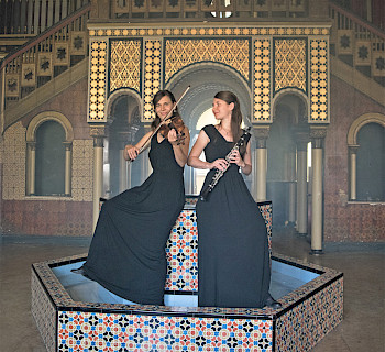 2 Frauen spielen Geigher und Klarinette auf Mosaik Boden
