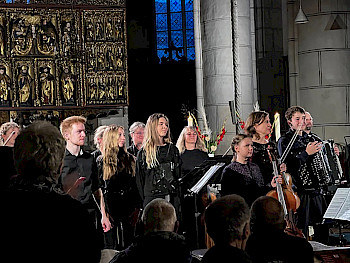 Junge Musikerinnern und Musiker mit ihren Instrumenten in einer Kirche