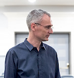Profilbild eines schlanken Mannes mit Brille und grauen kurzen Haaren