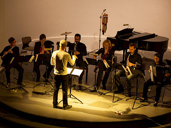 Musiker und Dirigent auf einer Bühne beim Musizieren