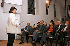 Eine Frau macht ihre Lesung vor einem großen Publikum