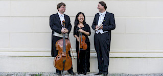 3 Musiker, 1 mit Cello, 1 mit Geigher, 1 mit Tropete
