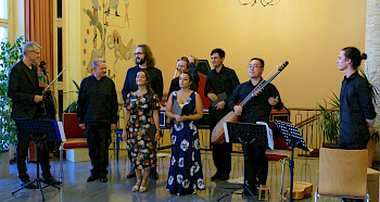 Die Sängerinnen und Sänger von der HfM Berlin sowie das Instrumentalensemble stehen nebeneinander