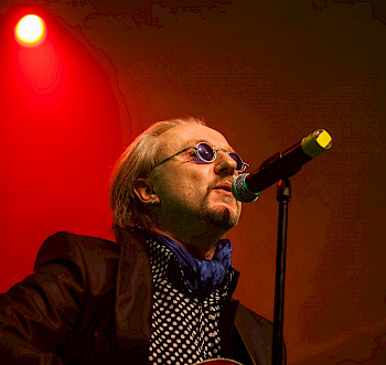 Ein Mann mit Brille singt vor dem roten Licht