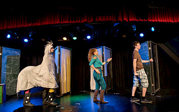 2 Menschen und 2 Menschen in Klamotten von einem Kamel laufen auf der Bühne