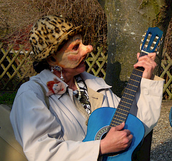 Eine Frau mit Maske und blauer Gitarre