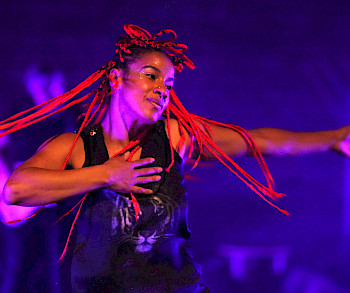 1 afrikanische Frau mit roten Haaren tanzt in blauen Licht