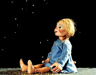 1 Puppe mit blonden Haaren sitzt unter Sternenhimmel