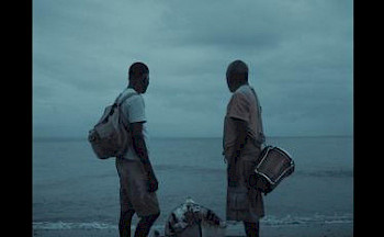 2 schwarze Männer stehen vor dem Meer