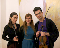 Zwei junge Frauen, eine davon mit schwarzer Blockflöte, neben einem jungen Mann mit Violine vor einem Ölgemälde