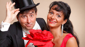 Ein Mann und eine Frau posieren mit einer roten Blume vor dem Kamera