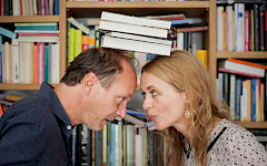 1 Mann und 1 Frau versuchen die Bücher auf den Köpfen zu balancieren