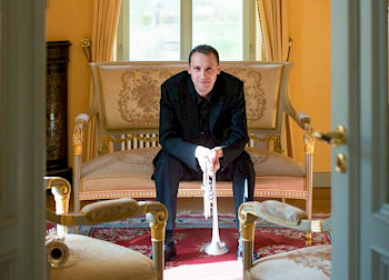 Joachim Karl Schäfer sitz mit seiner Trompeten im luxusen Zimmer