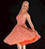Sonja Walter ist glücklich in einem orangen Kleid