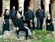 Mitglieder des Ensemble Gilles Binchois stehen vor mittelalterlicher Kulisse