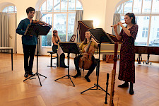4 Musiker mit Barockinstrumenten musizieren auf einer Bühne
