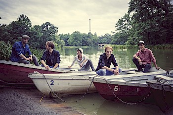 fünf junge Männer sitzen auf Booten