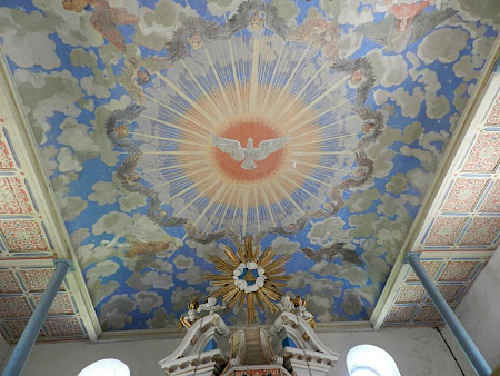 Kirchendecke, die eine weiße Taube in der Mitte zeigt, mit blau, gelben, orangenen Farben
